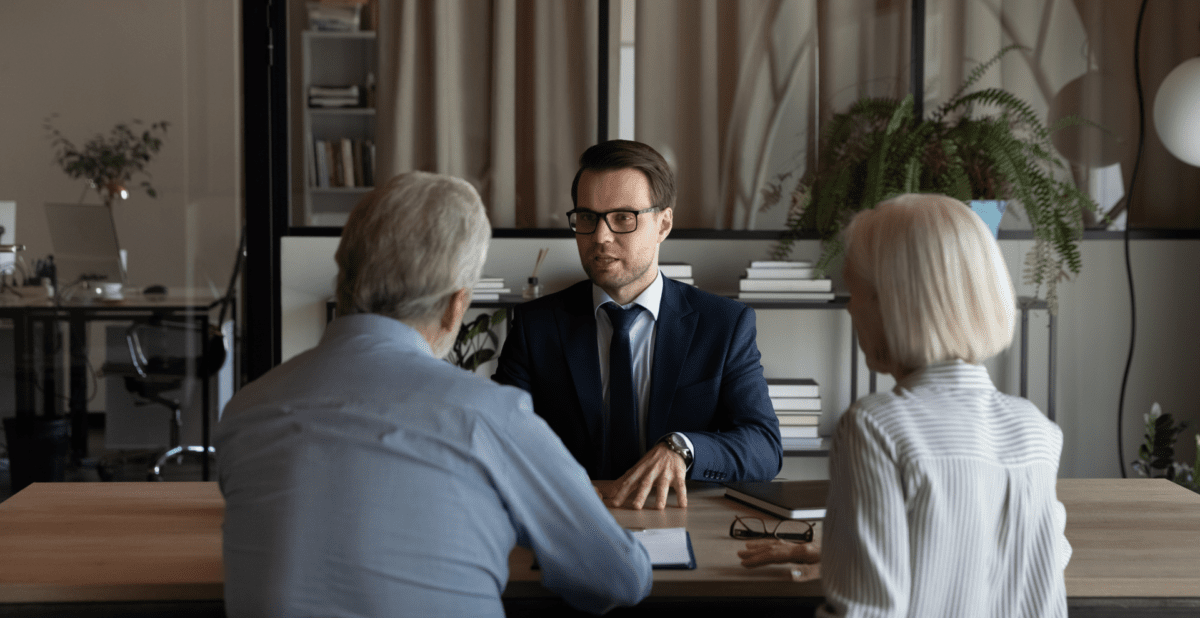 a person sitting at a table talking to his clients